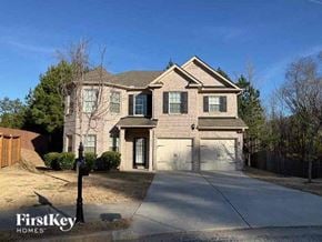 Fairburn house for rent - a brick house with two garage doors and a driveway