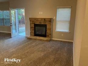 Fairburn house for rent - a living room with a stone fireplace and a door