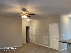 Fairburn house for rent - an empty living room with a ceiling fan and a door