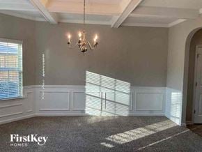 Fairburn house for rent - an empty dining room with a chandelier and window