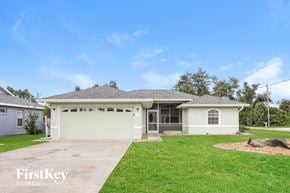Rotonda West house for rent - a white house with a lawn and a driveway
