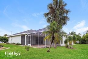Rotonda West house for rent - a house with palm trees in front of it