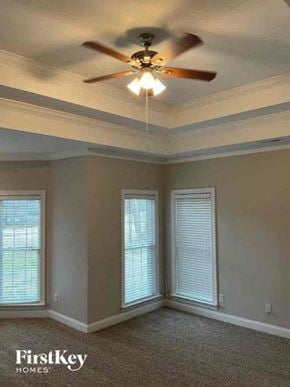 Statesville house for rent - a living room with a ceiling fan and two windows
