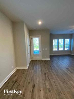 Summerville house for rent - an empty living room with wood floors and a door