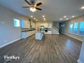 Summerville house for rent - an empty living room and kitchen with a ceiling fan