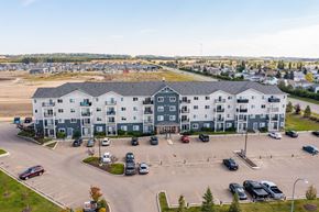 Red Deer apartment for rent - A large white building with a parking lot in front.