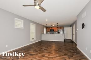St Charles house for rent - A spacious room with wooden floors and a ceiling fan.