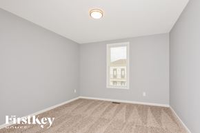 St Charles house for rent - A room with a carpeted floor and a window showing a building outside.