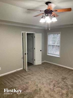Charlotte house for rent - an empty bedroom with a ceiling fan and a door