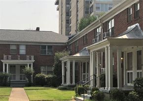 Memphis apartment for rent - A red brick house with a white porch and a black metal railing.