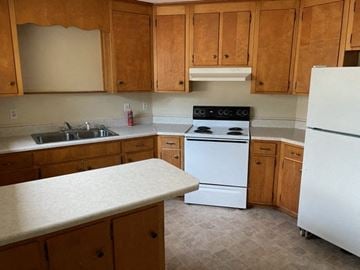 Cedartown apartment for rent - a kitchen with white appliances and wooden cabinets
