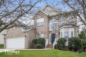 High Point house for rent - A brick house with a black door and a white garage door.