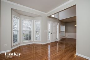 High Point house for rent - A room with wooden floors and a door leading to another room.
