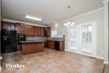 High Point house for rent - A kitchen with a black refrigerator and wooden cabinets.