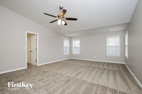 High Point house for rent - A spacious room with a ceiling fan and carpeted floor.