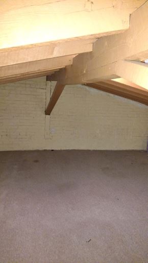 Easton apartment for rent - A white brick wall with a wooden beam.