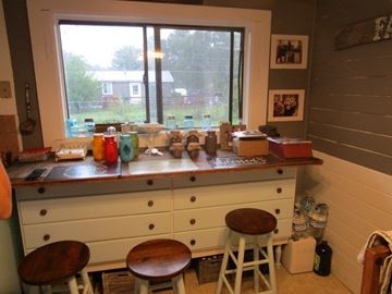 Lakeside house for rent - a kitchen with three stools in front of a window