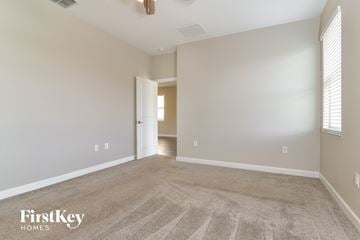 Davenport house for rent - a spacious living room with carpet and a door to a hallway