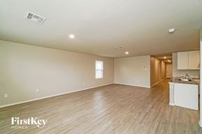 San Antonio house for rent - an empty living room and kitchen with wood flooring