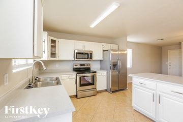 Maricopa house for rent - A kitchen with white cabinets and appliances.
