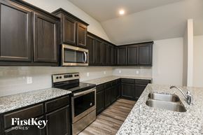 Fort Worth house for rent - a kitchen with granite counter tops and black cabinets