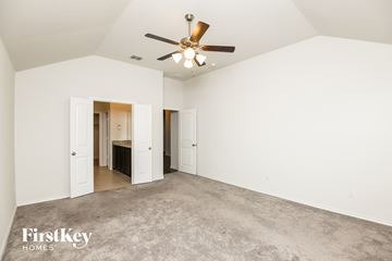 Fort Worth house for rent - a living room with carpet and a ceiling fan