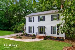 Charlotte house for rent - a white house with black shutters and a lawn and trees