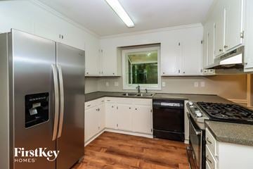Charlotte house for rent - a kitchen with white cabinets and a stainless steel refrigerator