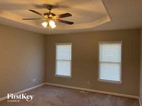 Hiram house for rent - a bedroom with a ceiling fan and two windows