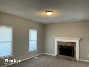 Hiram house for rent - an empty living room with a fireplace and two windows