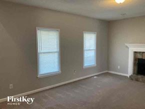 Hiram house for rent - an empty living room with a fireplace and two windows