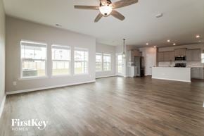 Summerville house for rent - A spacious room with wooden floors and a ceiling fan.