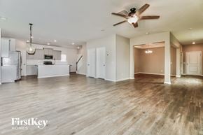 Summerville house for rent - A spacious room with a ceiling fan and wooden flooring.