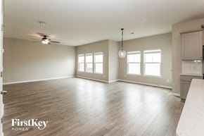 Summerville house for rent - A spacious room with wooden floors and a ceiling fan.