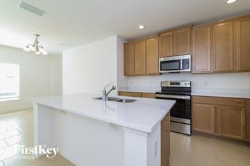 Davenport house for rent - a white kitchen with wooden cabinets and a white counter top