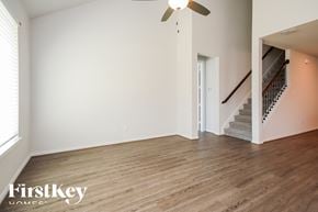 Katy house for rent - A spacious room with wooden flooring and a staircase.