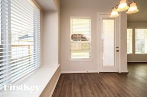 Katy house for rent - A room with a window covered by white blinds and a door.