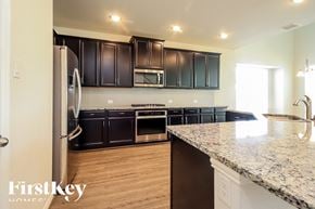 Katy house for rent - A kitchen with a granite countertop and a refrigerator.