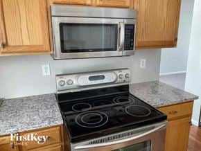 Delaware house for rent - A stainless steel microwave oven is mounted above a stove in a kitchen.