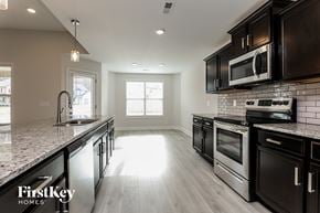 Clarksville house for rent - a kitchen with stainless steel appliances and marble counter tops