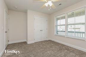 Clarksville house for rent - a bedroom with a ceiling fan and a window