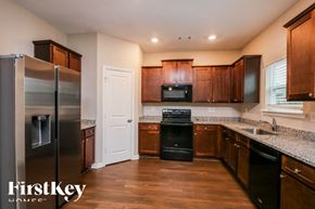 Pendergrass house for rent - A kitchen with wooden cabinets and a stainless steel refrigerator.