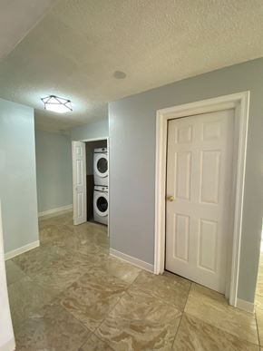 Tamuning house for rent - an empty hallway with a white door and a laundry room with a washer and