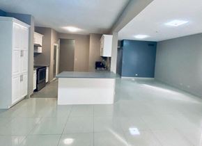 Tumon house for rent - an empty kitchen with a white island in the middle