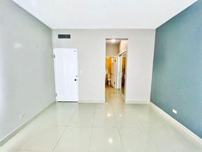 Tumon house for rent - an empty living room with a white tile floor and blue walls
