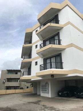 Tumon house for rent - a white building with a car parked in front of it