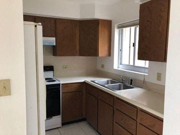 Sinajana apartment for rent - a kitchen with a sink a stove and a window