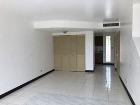 Sinajana apartment for rent - an empty living room with a tile floor and a door