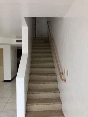 Sinajana apartment for rent - a staircase with a wooden hand rail and a white wall