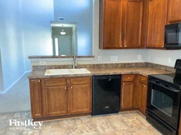 Matthews house for rent - a kitchen with wooden cabinets and black appliances